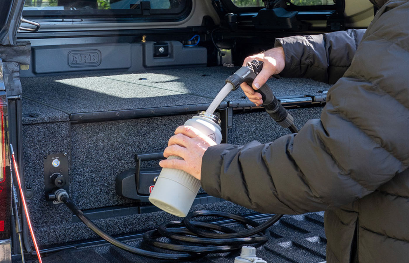 De krachtige waterstraal uit de 12V-pomp van de tank.